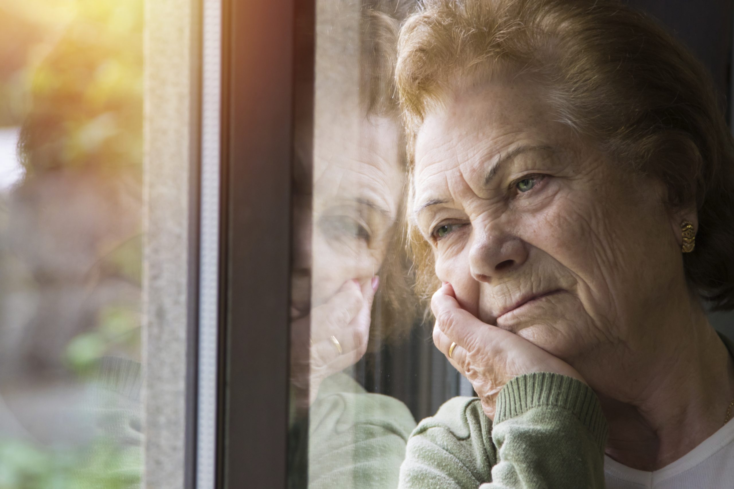 portrait of senior woman looking out the window