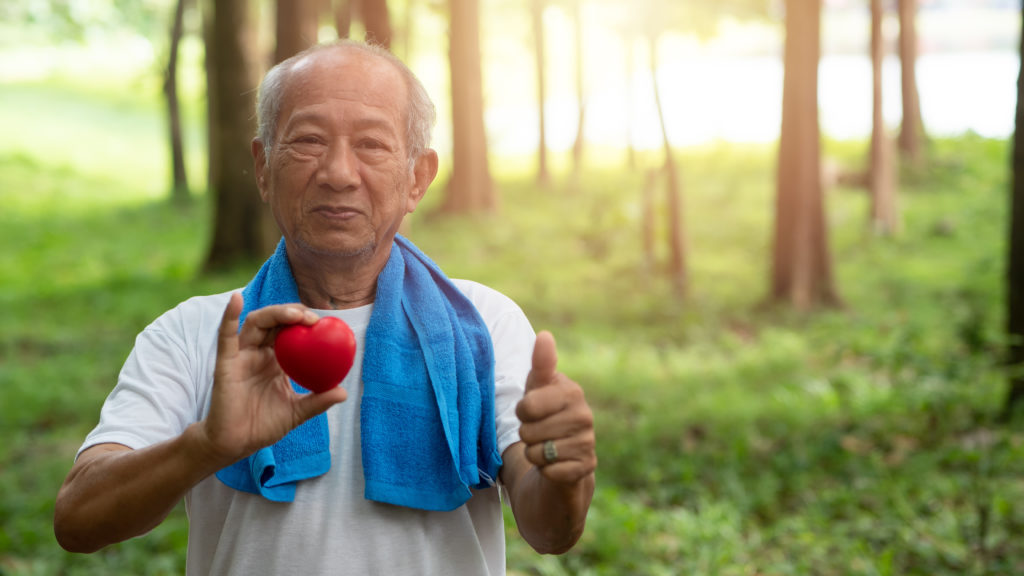 Male senior holding red heart . appears Healthy after exercise