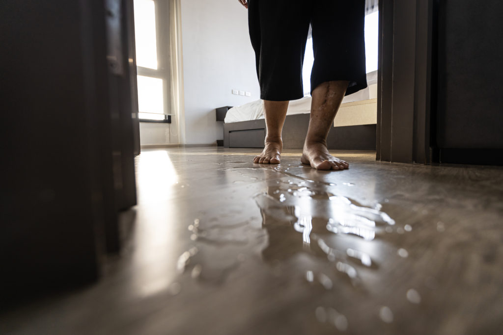 Careful of hazard, senior woman is stepping on the wet floor