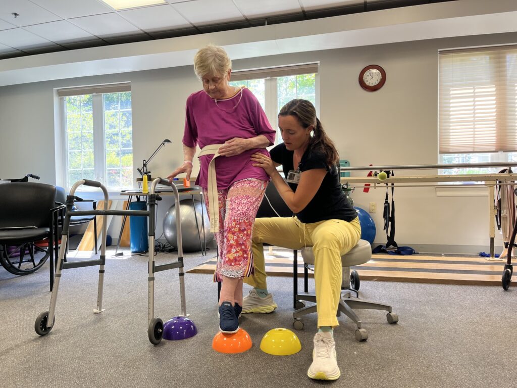 Physical Therapist assisting senior with exercise